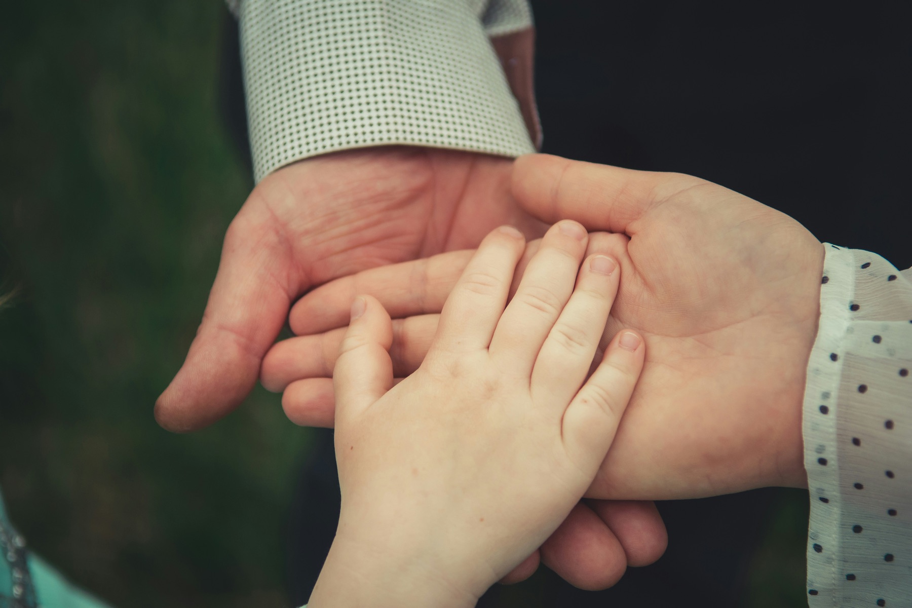 A parent’s and a child’s hands resting together