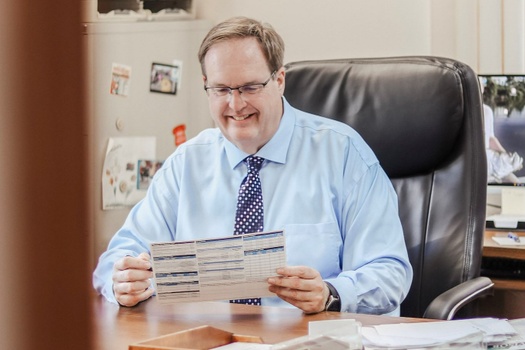 Mike Klauke reviewing account statements at his desk